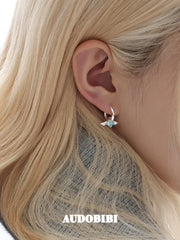 Mini wing-and-star hoop earrings, shown in a close-up of the ear.