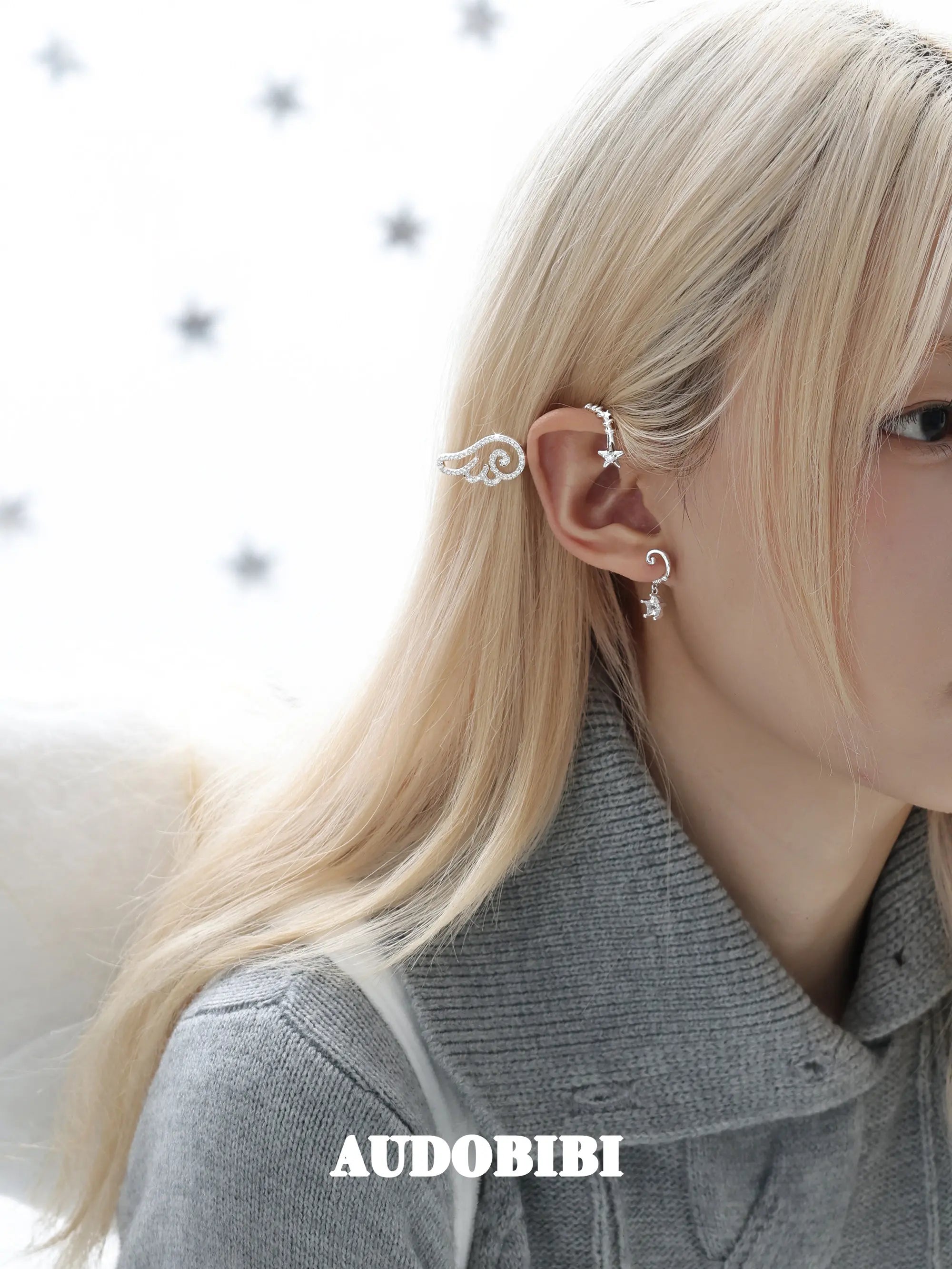 Large openwork wing ear cuff, worn with other jewelry in a model portrait.