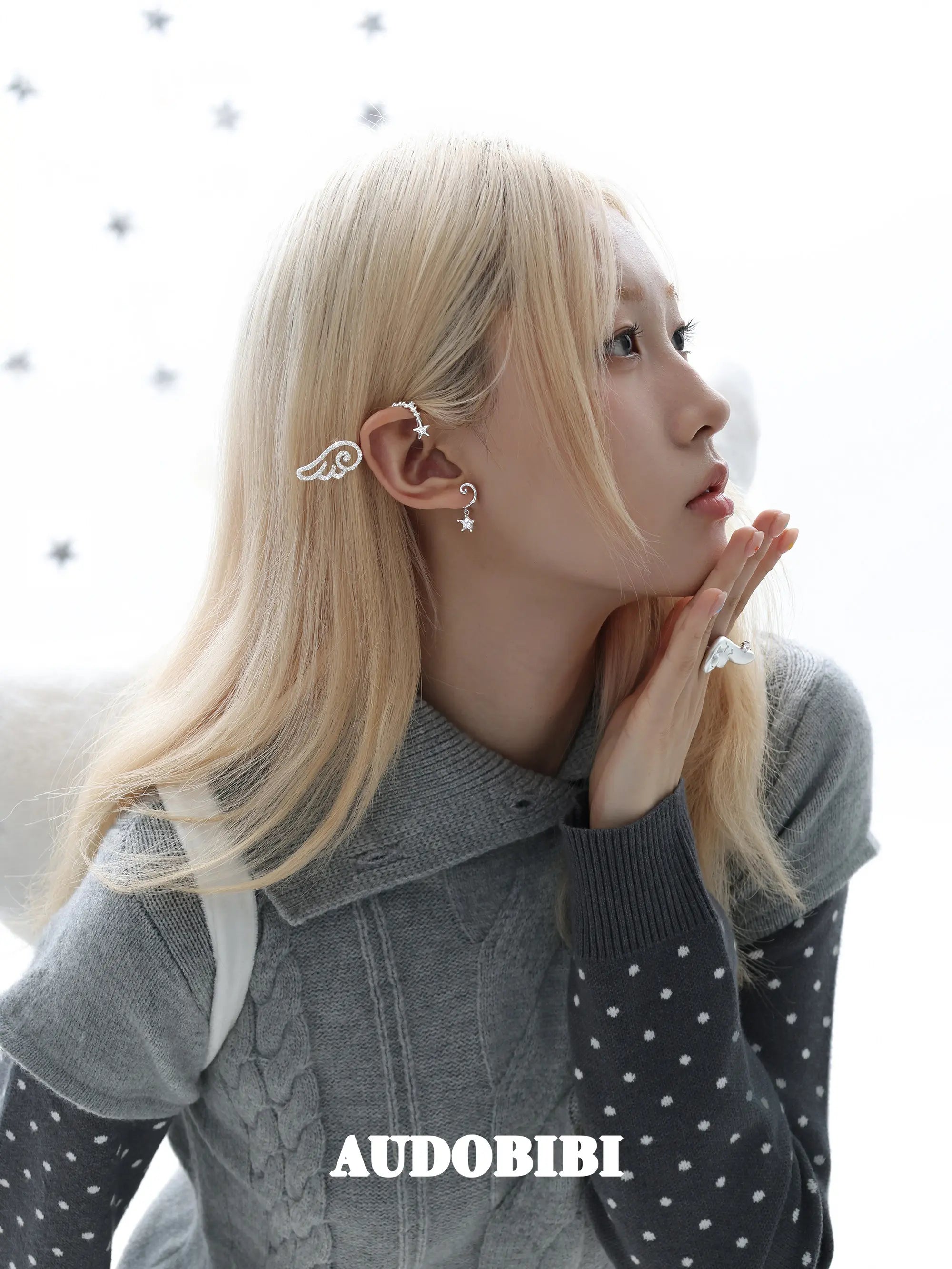 Large openwork wing ear cuff, worn with other jewelry in a model portrait.