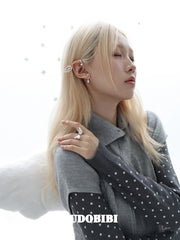 Large openwork wing ear cuff, worn with other jewelry in a model portrait.