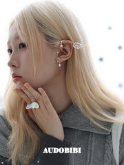 Large openwork wing ear cuff, worn with other jewelry in a model portrait.