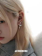 Key and heart-lock earrings, worn with other jewelry in a model portrait.