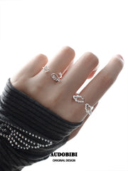 Winged Grace Wing Slumber Zircon Angel Wing Open Ring, shown worn by a model.