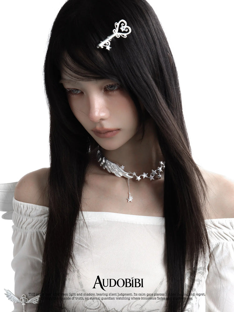 Ornate key hair clip, worn with other jewelry in a model portrait.