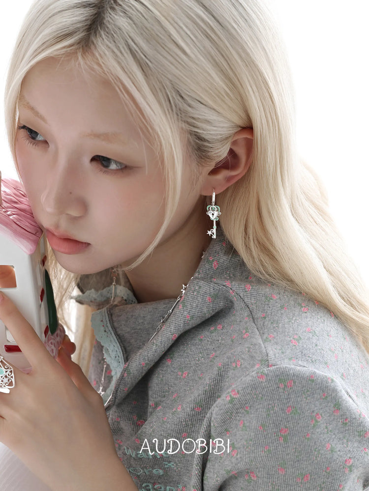Lily Dreamlock Asymmetric Heart-Key Drop Earrings, shown worn by a model.
