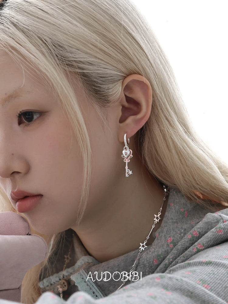 Lily Dreamlock Asymmetric Heart-Key Drop Earrings, shown worn by a model.