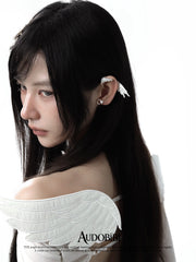 Wing ear cuff, worn with other jewelry in a model portrait.