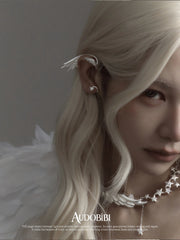 Wing ear cuff, worn with other jewelry in a model portrait.