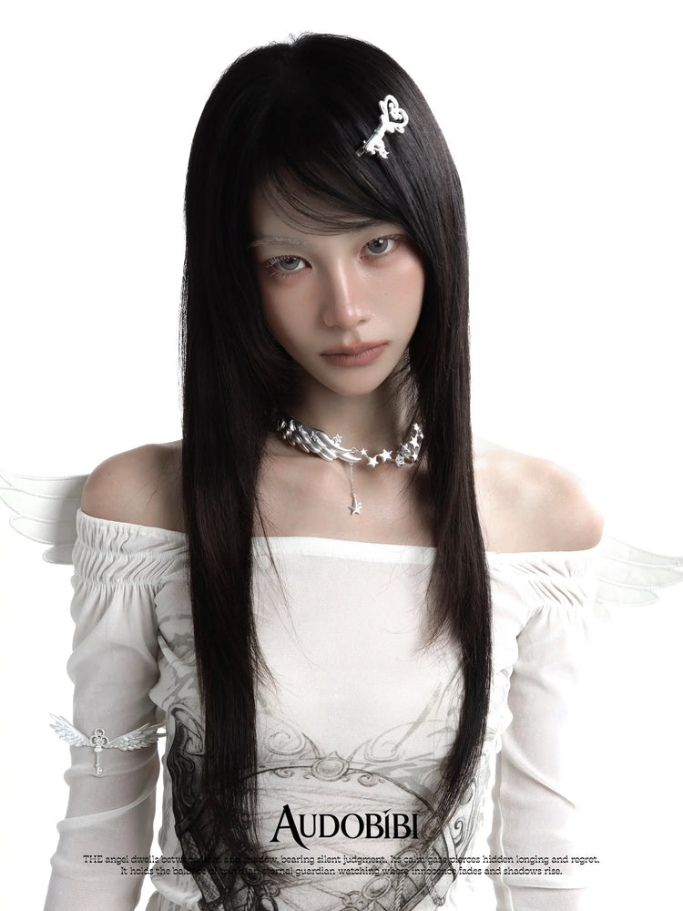 Wing-and-key arm cuff, worn with other jewelry in a model portrait.