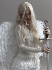 Wing-and-key arm cuff, worn with other jewelry in a model portrait.