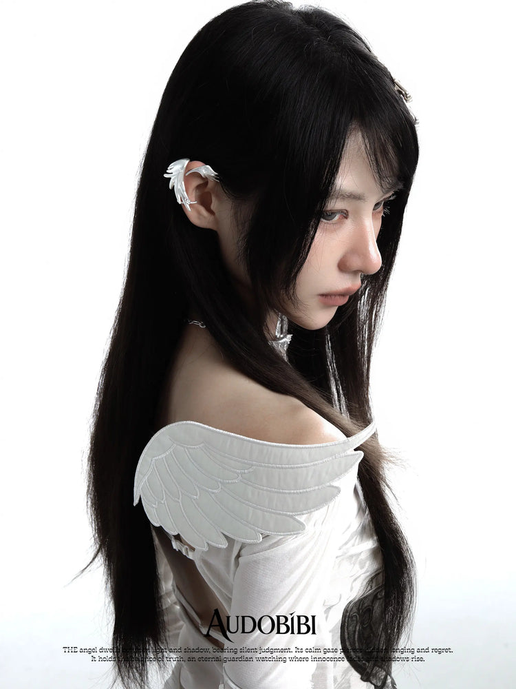 Long wing ear cuffs, worn with other jewelry in a model portrait.