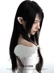 Long wing ear cuffs, worn with other jewelry in a model portrait.