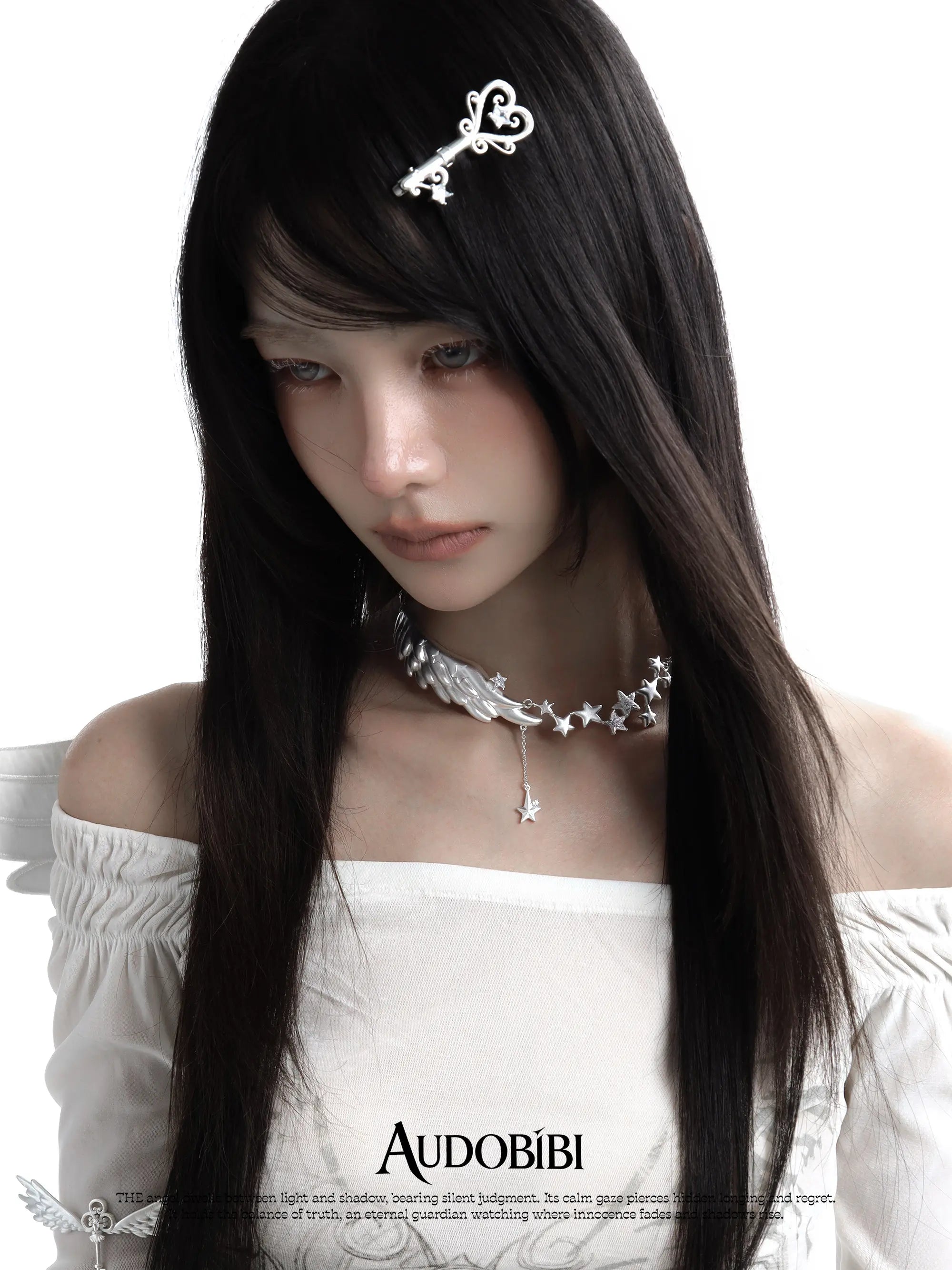 Wing-and-star necklace, worn with other jewelry in a model portrait.