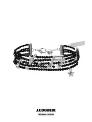 Black bead musical-note bracelet viewed from the front.