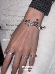 Musical-note pinky ring, shown on the hand or wrist with other jewelry.