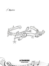 Open bangle shaped like a musical staff, with wing and hanging-star details.