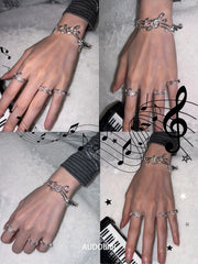 Musical-staff open bangle, shown on the hand or wrist with other jewelry.