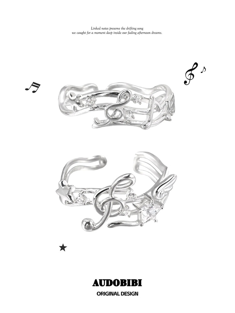 Two musical-note open-ring designs shown together.