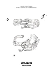 Two musical-note open-ring designs shown together.