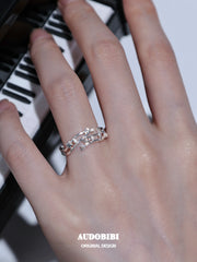 Musical-note open-ring designs, shown on the hand or wrist with other jewelry.