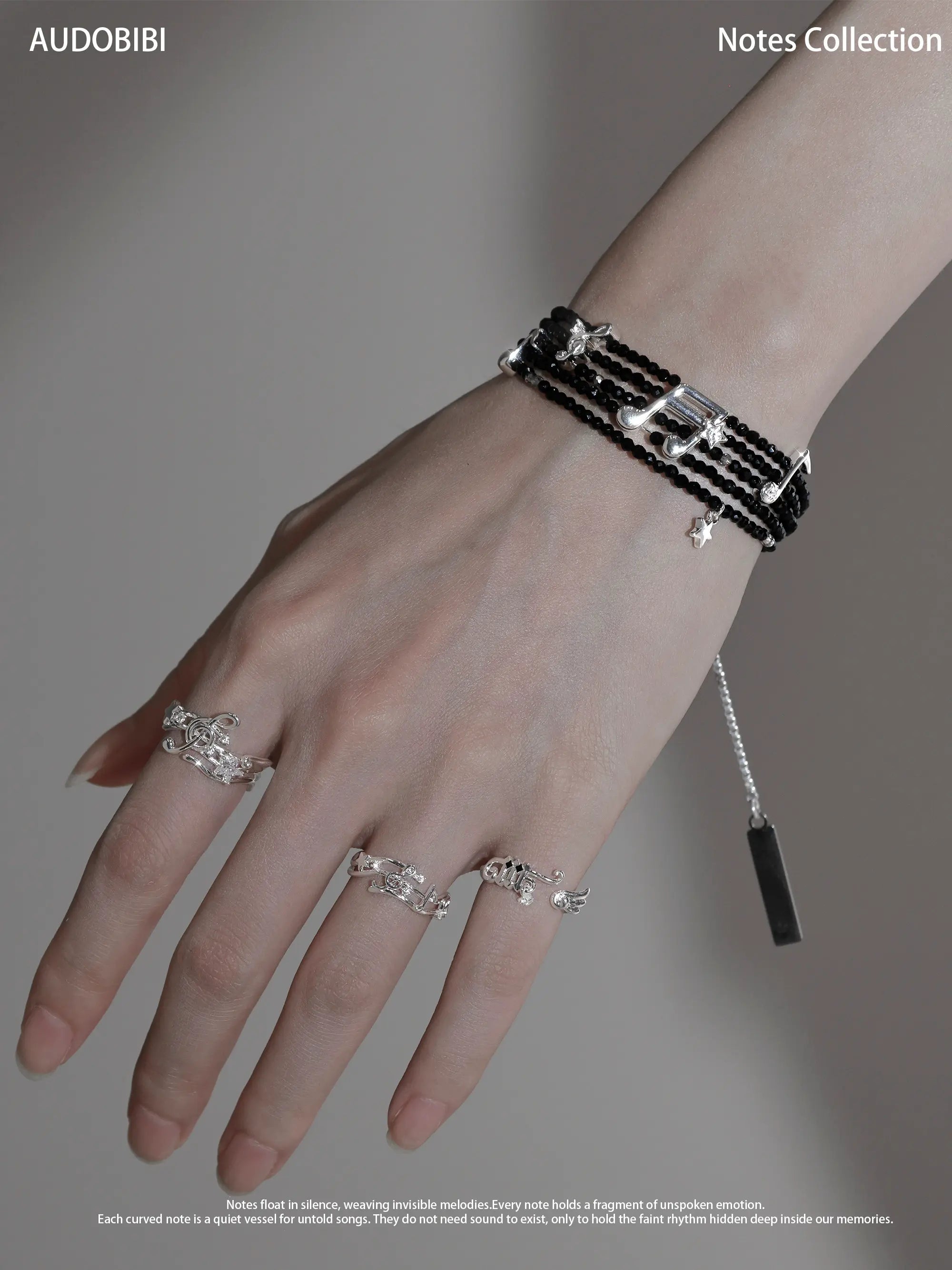 Musical-note open-ring designs, shown on the hand or wrist with other jewelry.