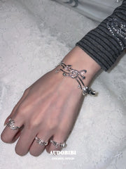 Musical-note open-ring designs, shown on the hand or wrist with other jewelry.