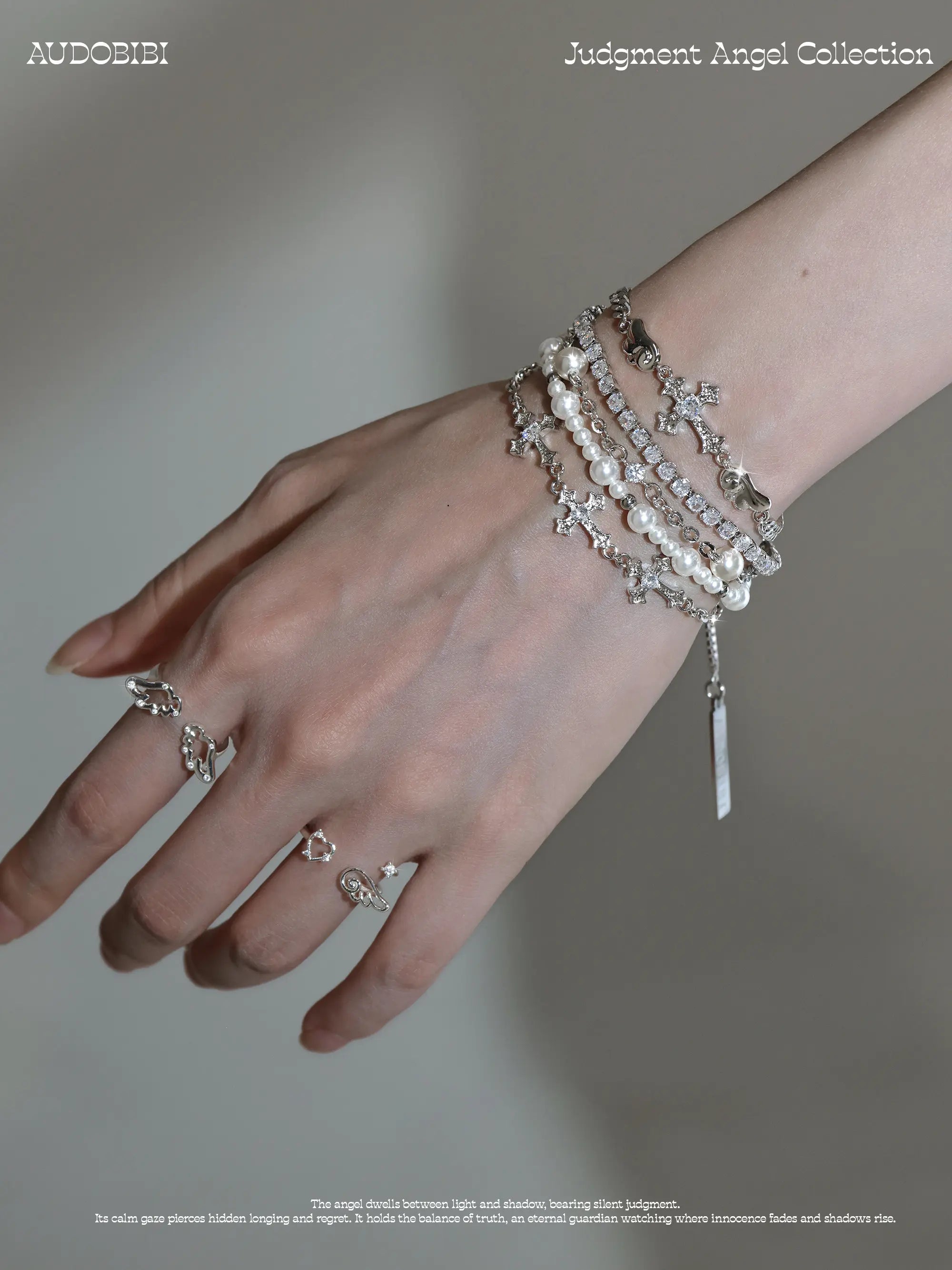 Layered bead bracelet with a hanging charm, worn with other jewelry in a model portrait.