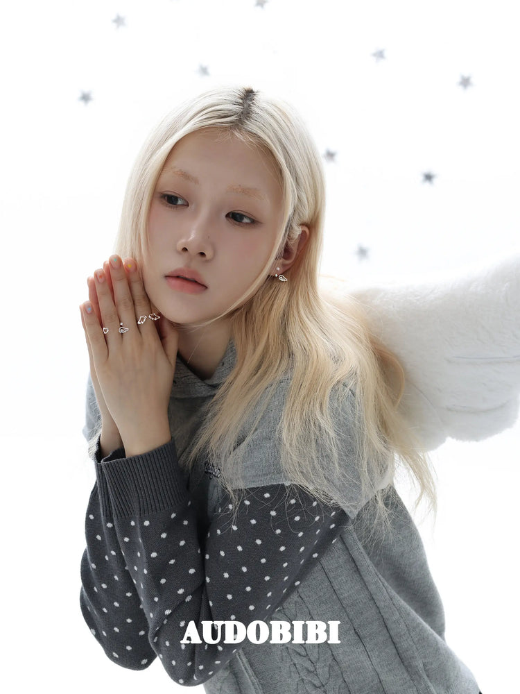 Star-and-wing stud earrings, worn with other jewelry in a model portrait.