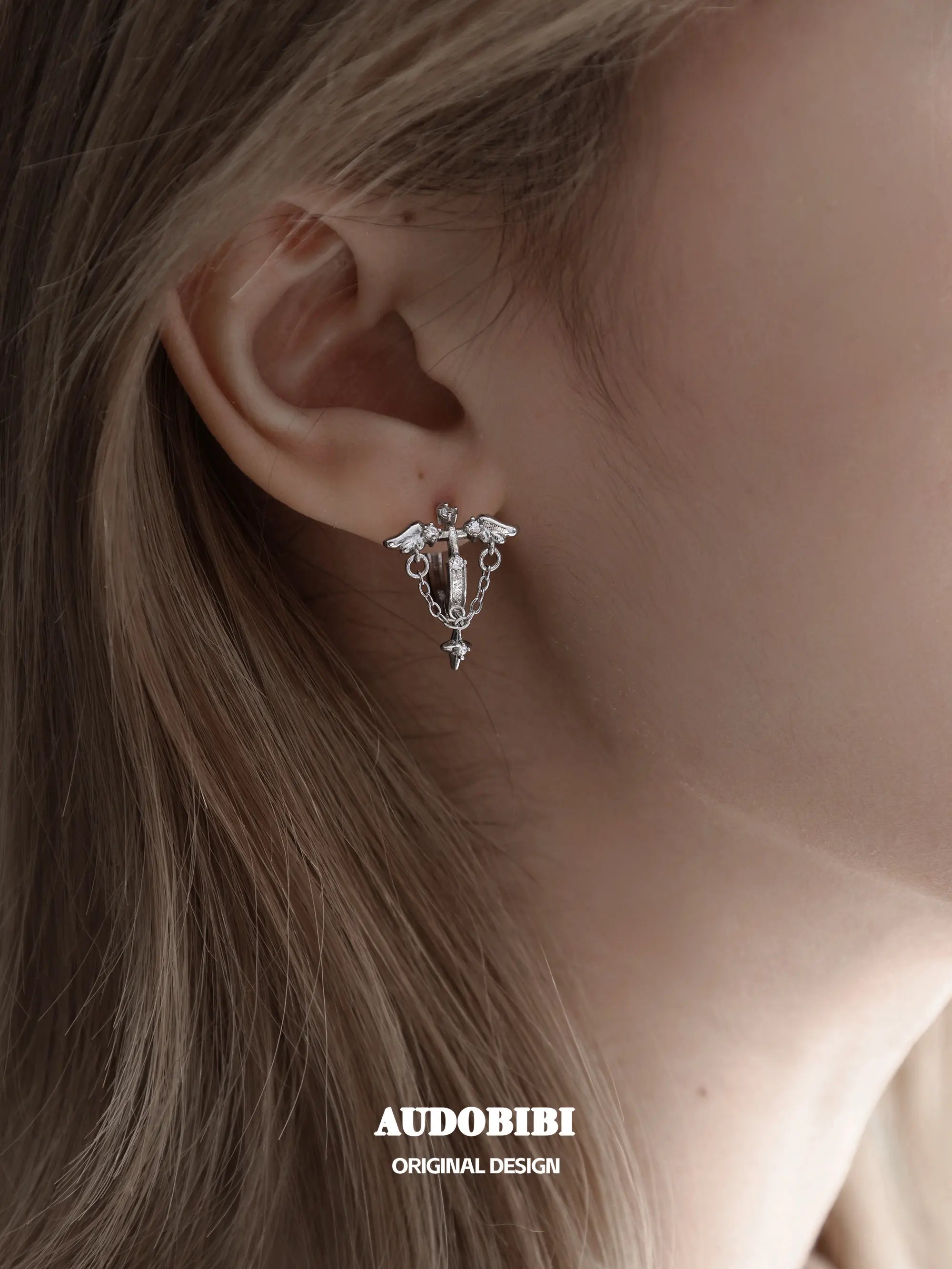 Winged Grace Judgment Angel Wing & Chain Hoop Earrings, shown worn by a model.