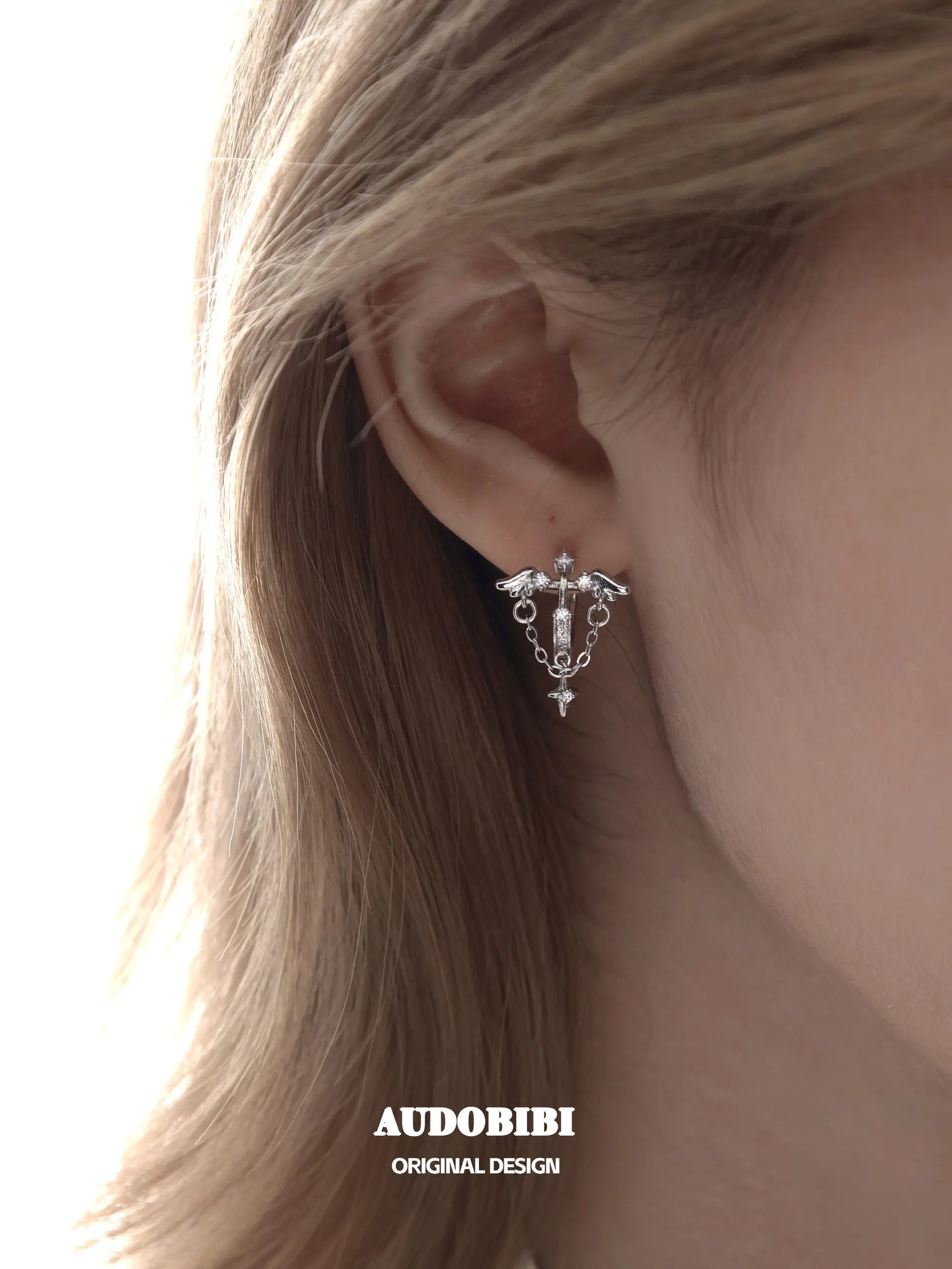 Winged Grace Judgment Angel Wing & Chain Hoop Earrings, shown worn by a model.