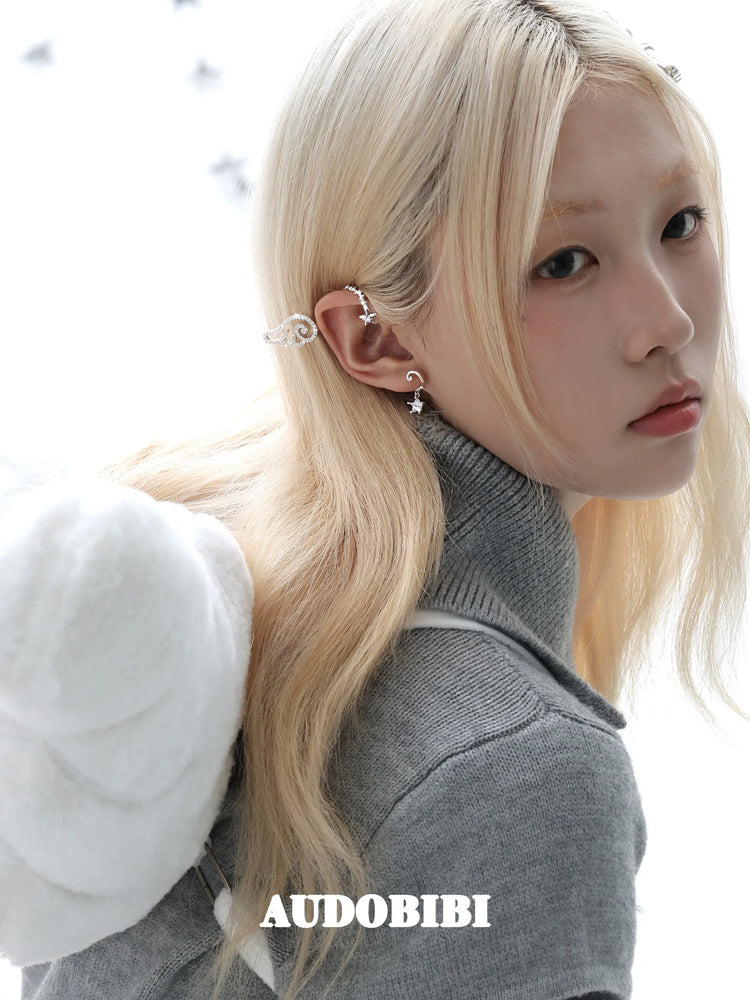 Large openwork wing ear cuff, worn with other jewelry in a model portrait.