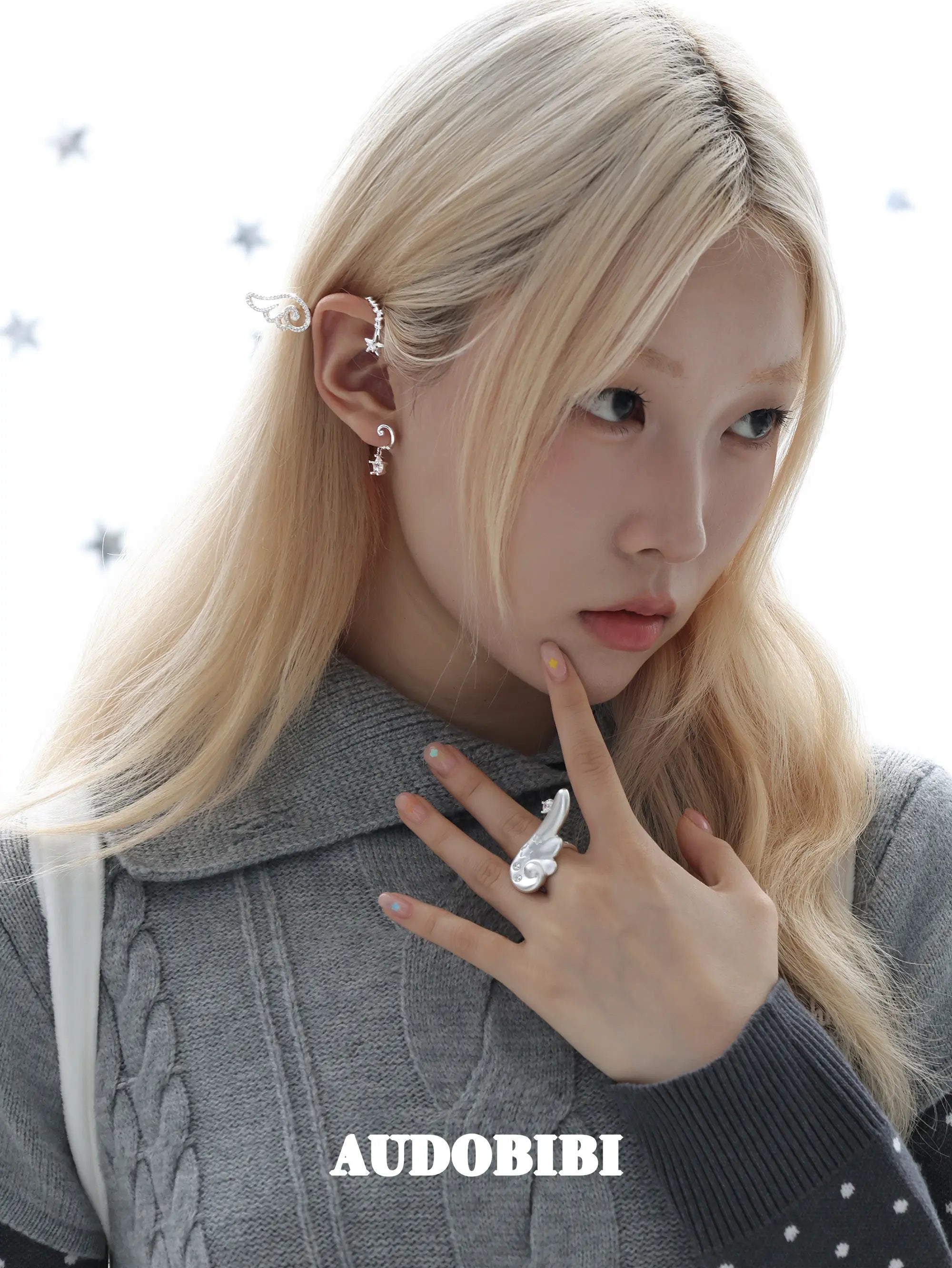 Large openwork wing ear cuff, worn with other jewelry in a model portrait.