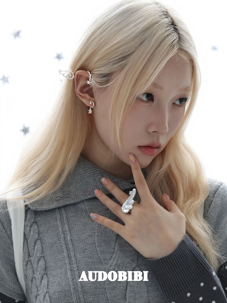 Large openwork wing ear cuff, worn with other jewelry in a model portrait.