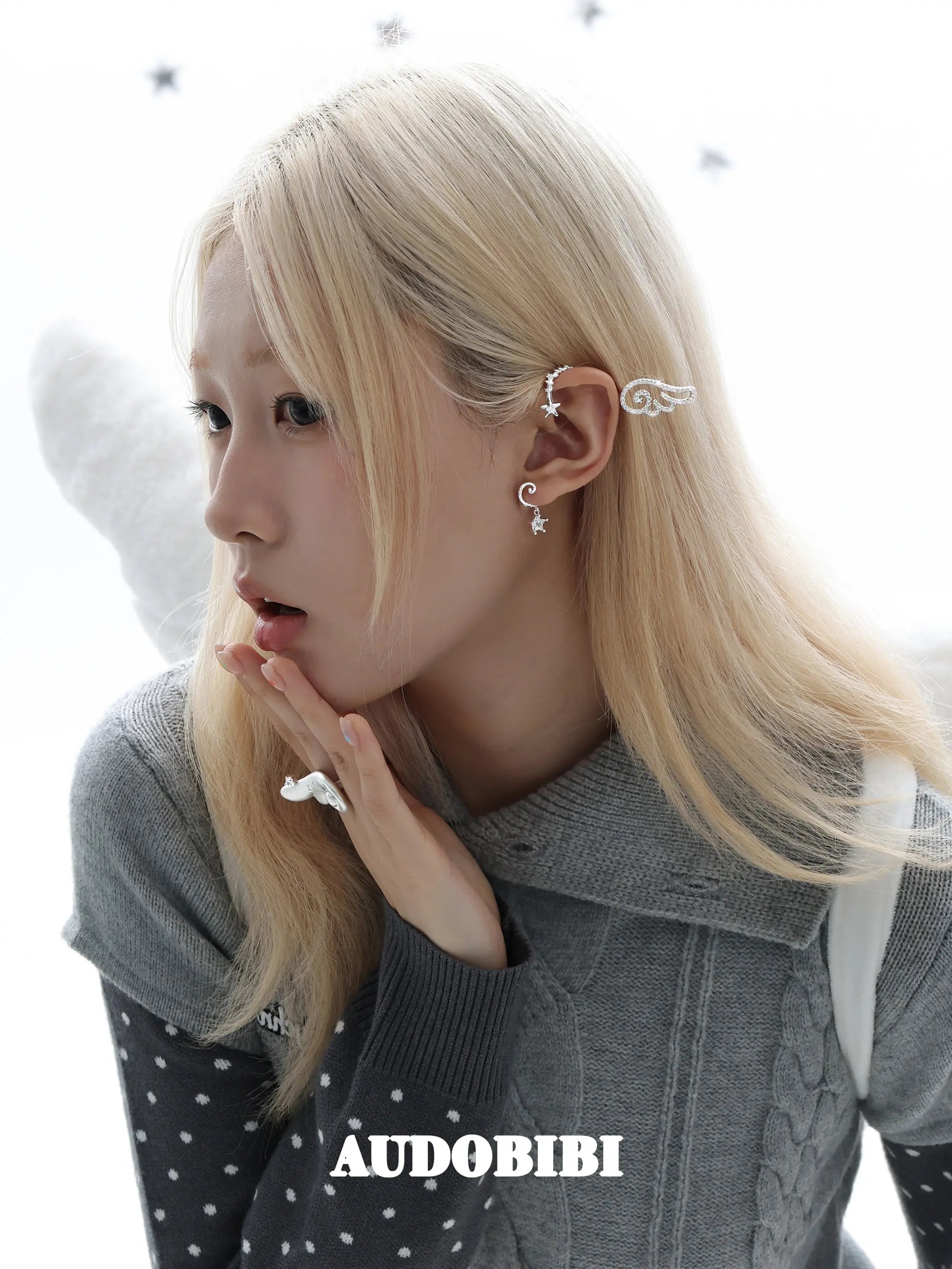 Large openwork wing ear cuff, worn with other jewelry in a model portrait.