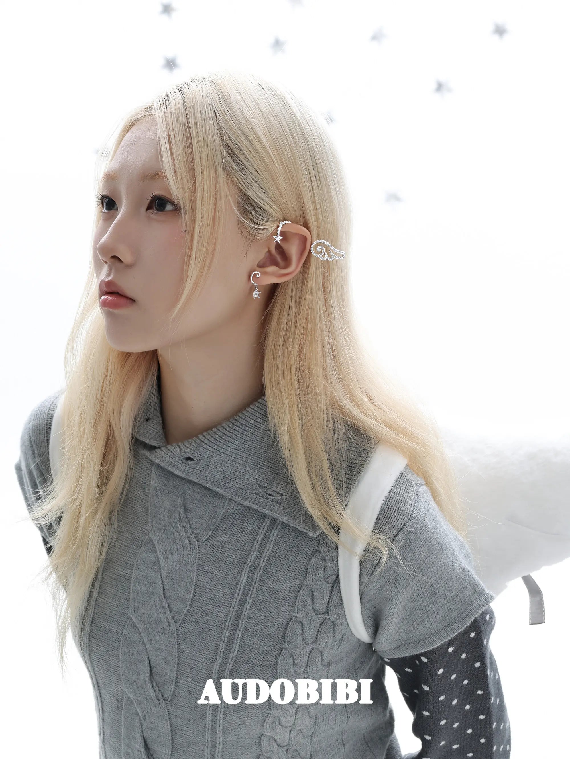 Large openwork wing ear cuff, worn with other jewelry in a model portrait.