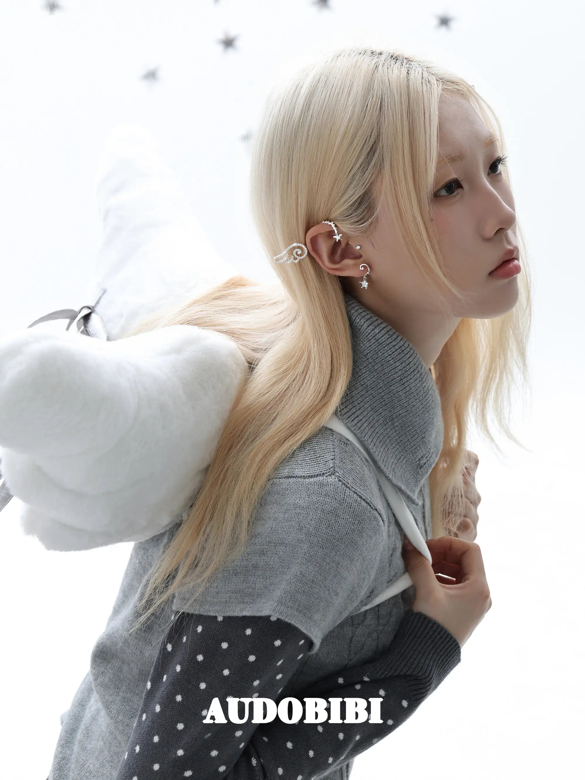 Large openwork wing ear cuff, worn with other jewelry in a model portrait.