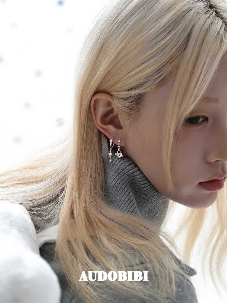 Key and heart-lock earrings, shown in a close-up of the ear.