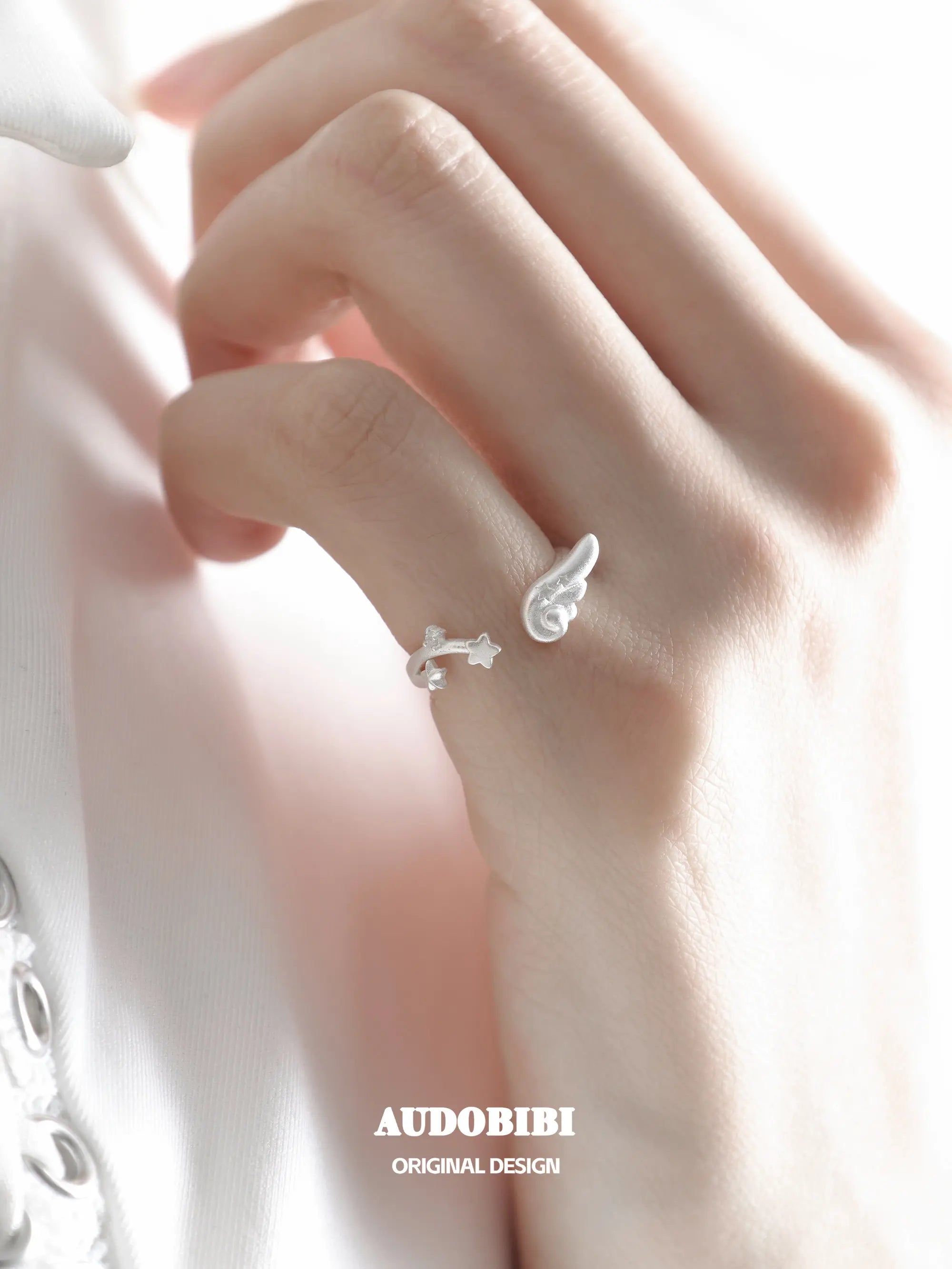 Winged Grace Dreamcore Angel Wing & Star Pinky Ring, shown worn by a model.