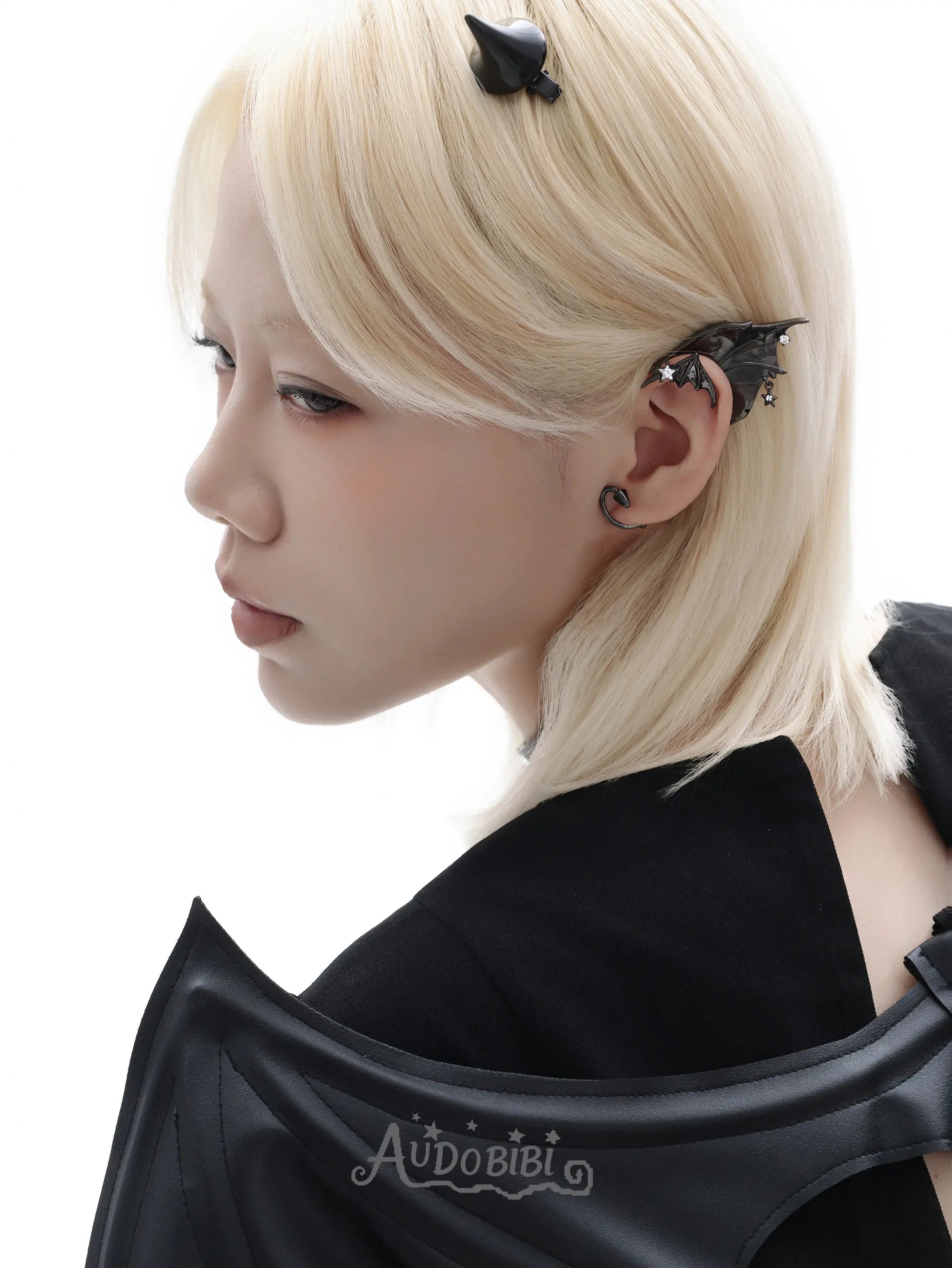 Black bat-wing ear cuff, shown in a close-up of the ear.