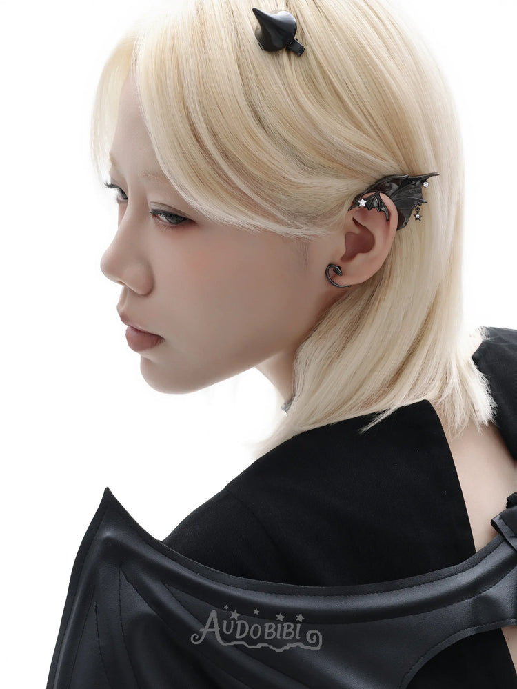 Black bat-wing ear cuff, shown in a close-up of the ear.