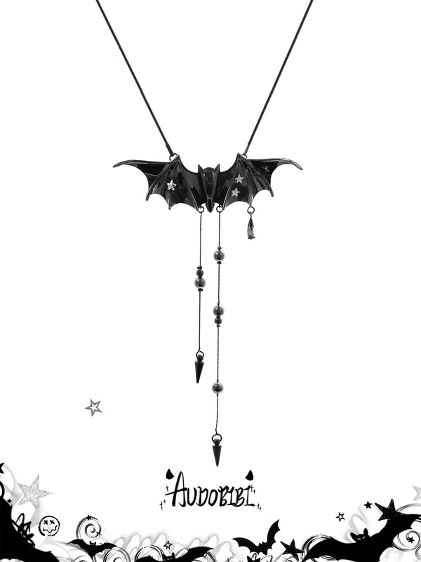 Black bat-wing pendant necklace with chains and pointed drops.