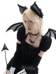 Black bat-wing pendant necklace, worn with other jewelry in a model portrait.