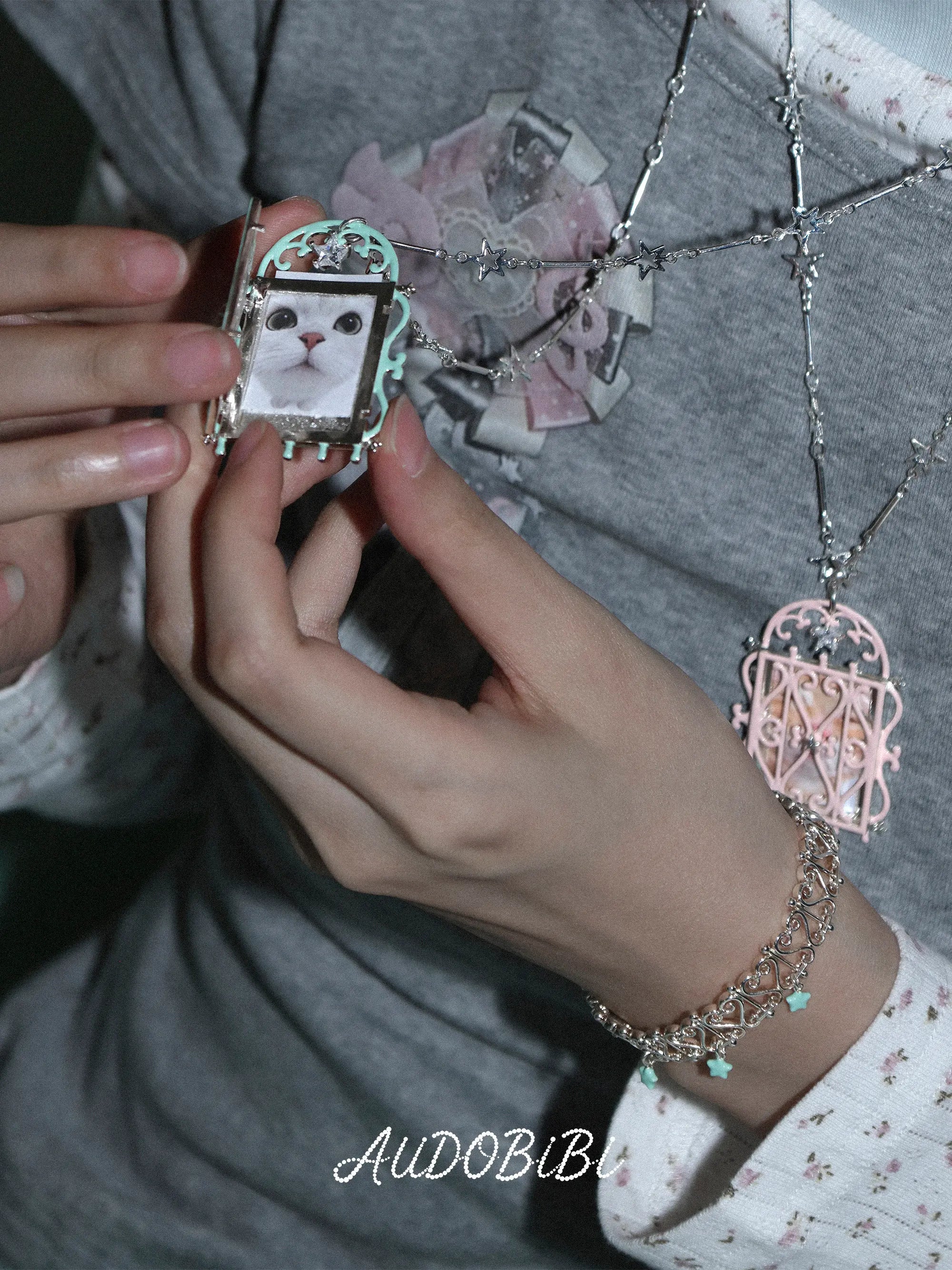 Openwork bangle with colored star drops, shown on the hand or wrist with other jewelry.