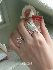 Openwork window ring with a hanging star, shown on the hand or wrist with other jewelry.