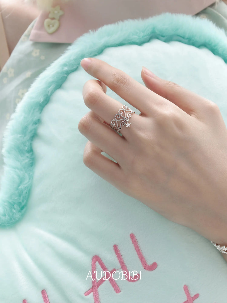 Openwork window ring with a hanging star, shown on the hand or wrist with other jewelry.