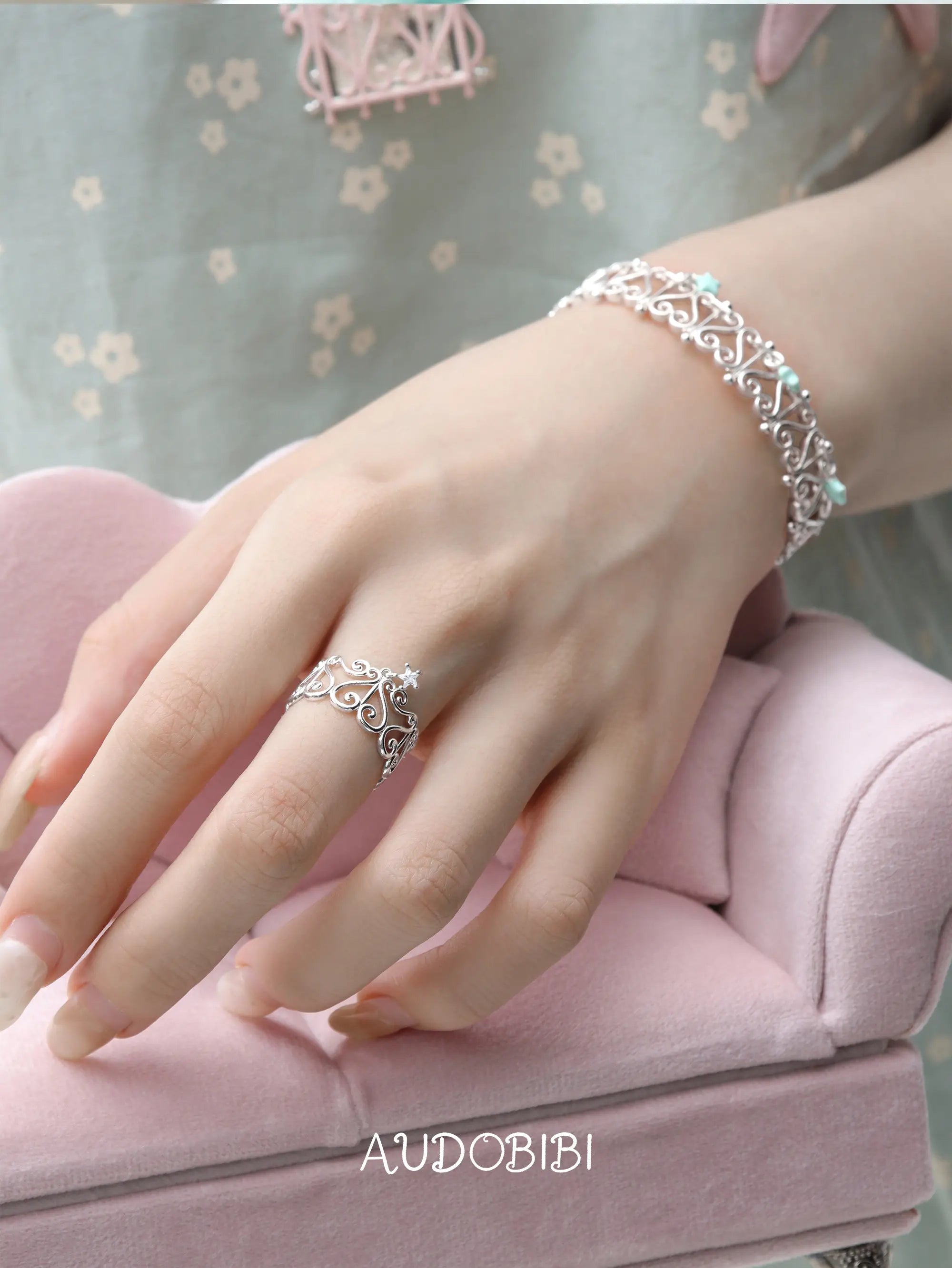 Openwork window ring with a hanging star, shown on the hand or wrist with other jewelry.