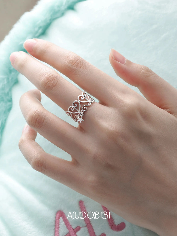 Openwork window ring with a hanging star, shown on the hand or wrist with other jewelry.