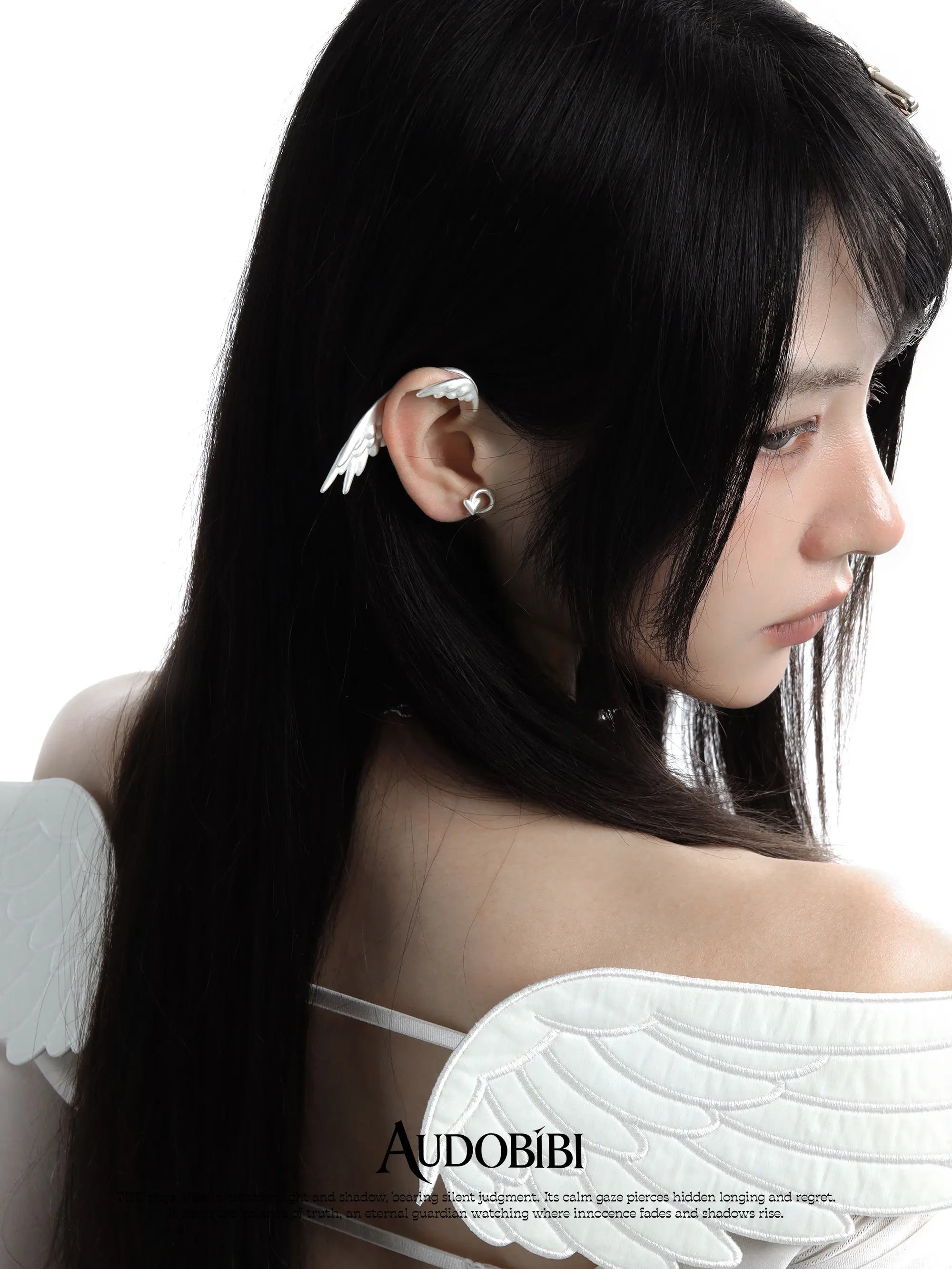 Wing ear cuff, worn with other jewelry in a model portrait.