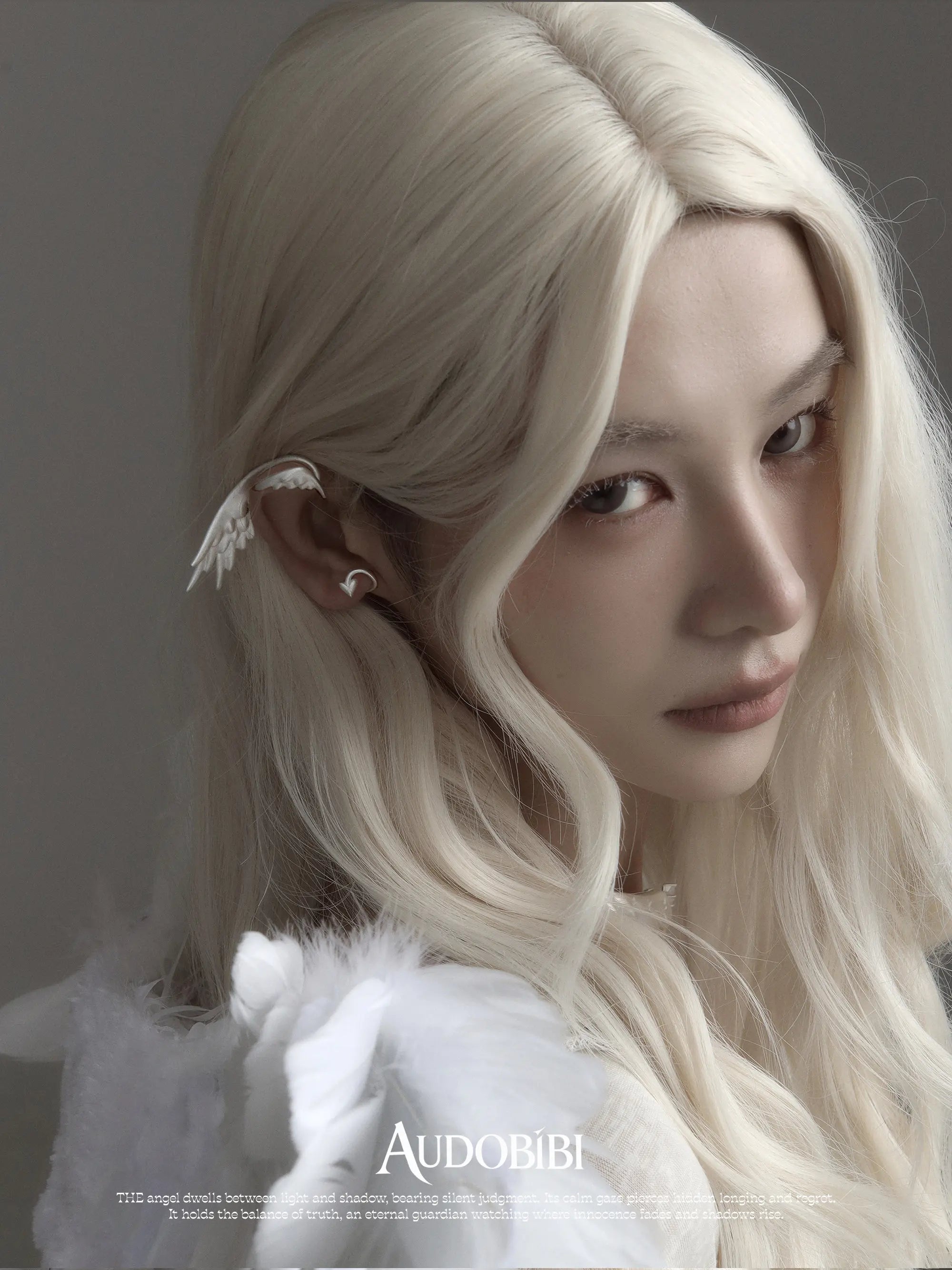 Wing ear cuff, worn with other jewelry in a model portrait.