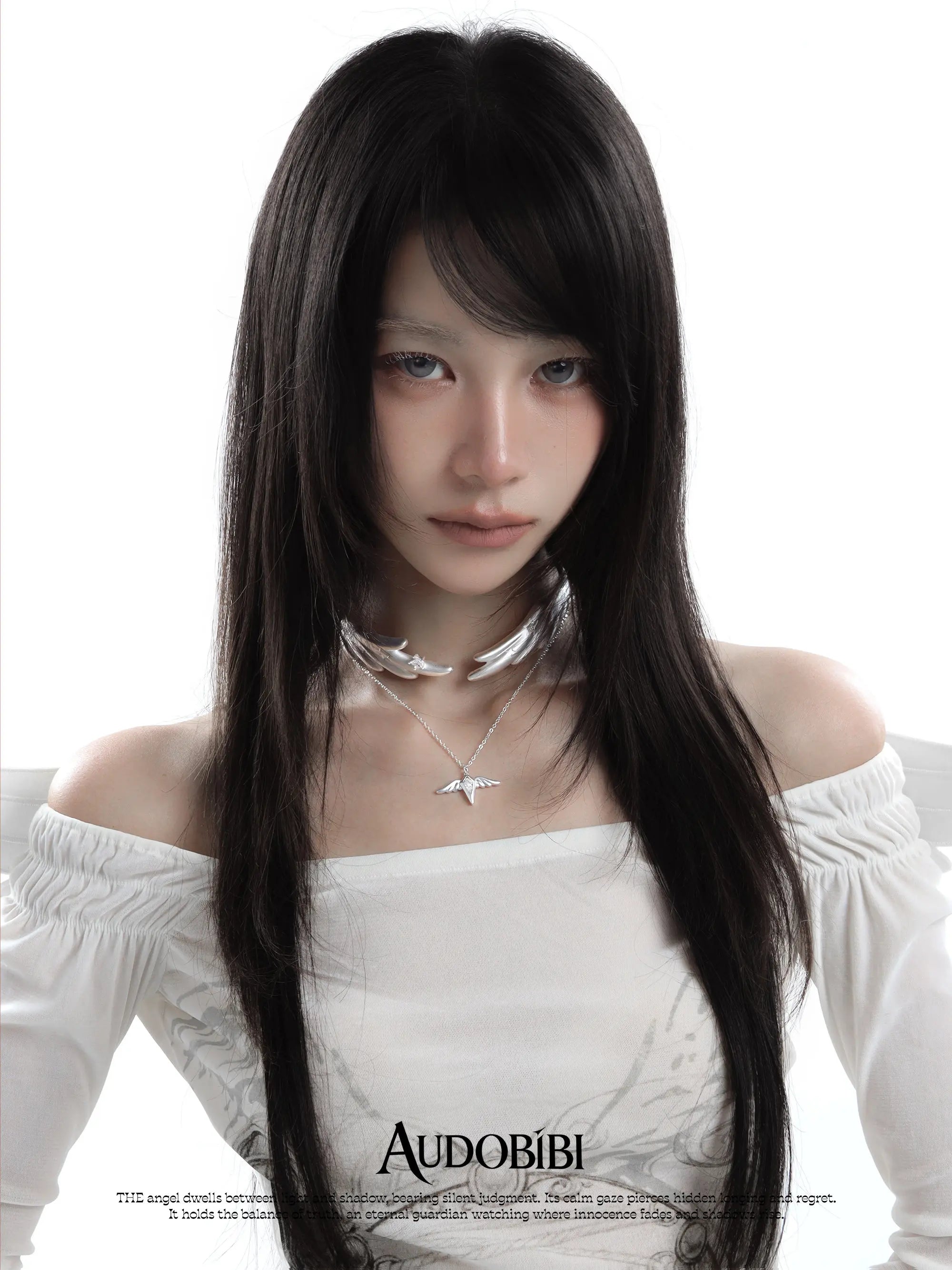 Wing choker with a draped chain, worn with other jewelry in a model portrait.